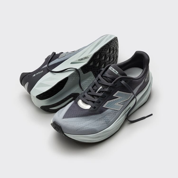 Mint and black running shoes on the ground and one is sideways